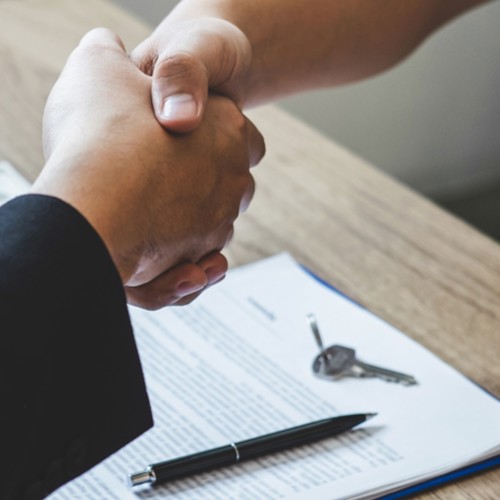 Finishing to successful deal of real estate, Broker and client shaking hands after signing contract approved application form, concerning mortgage loan offer for and house insurance